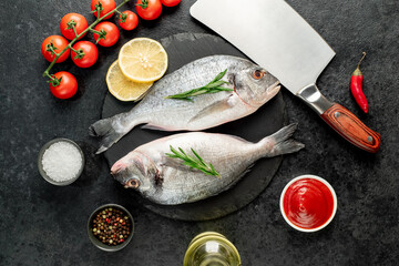 raw dorado fish with lemon and rosemary on stone background