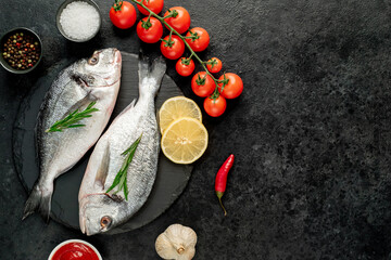 raw dorado fish with lemon and rosemary on stone background with copy space for your text