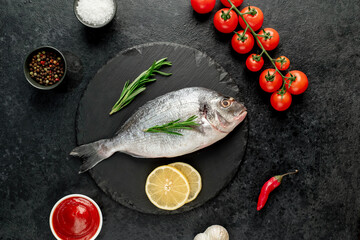 raw dorado fish with lemon and rosemary on stone background