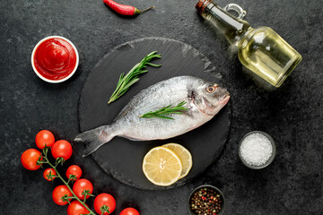 raw dorado fish with lemon and rosemary on stone background