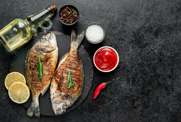 grilled dorado fish with lemon and rosemary on stone background with copy space for your text