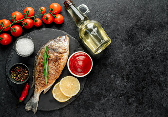 grilled dorado fish with lemon and rosemary on stone background with copy space for your text