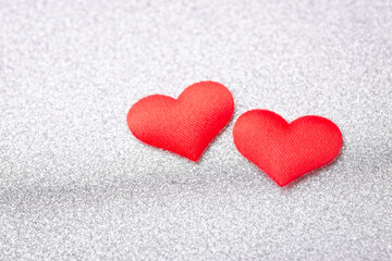 Two red hearts on silver background. Concept of love between people, devotion, romantic relationships