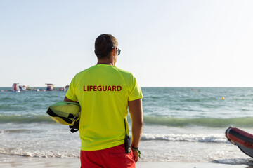Lifeguard observing sea on sandy beach