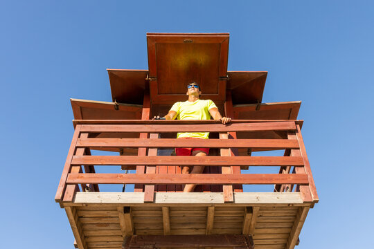 Lifeguard observing sea on beach watchtower