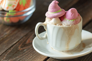 A mug of coffee, cocoa with marshmallows . Serving dessert for Halloween. Festive concept