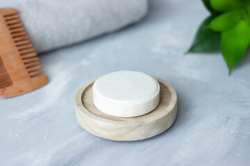 Close up of round bar of shampoo and soap on bamboo and textured background; spa theme; concept;...