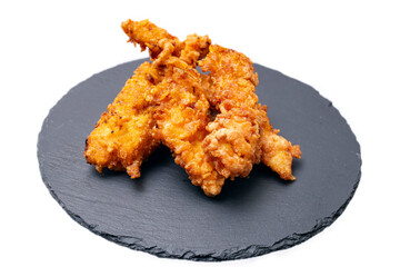 chicken strips, breast sticks coated with eggs and curcuma on a black stone tile