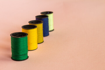 Spool or spools of colored threads on a neutral background. Free space to write.