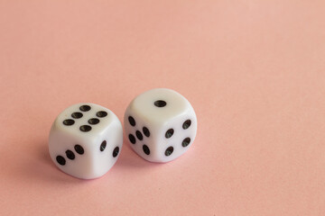 Plastic dice on a neutral pink background. Gambling addiction concept. Free space to write.