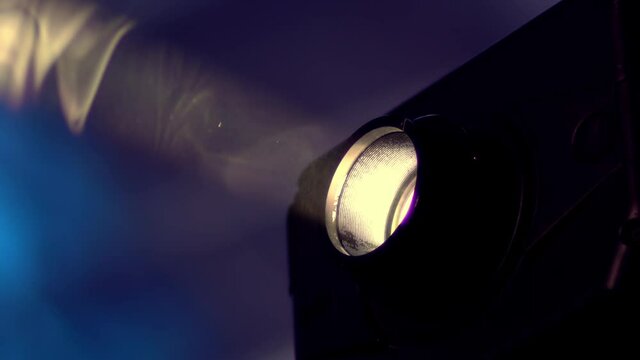 Macro of a projector lens beam light with dust particle blured background