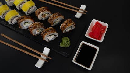 Sushi selection on black slate, food border background