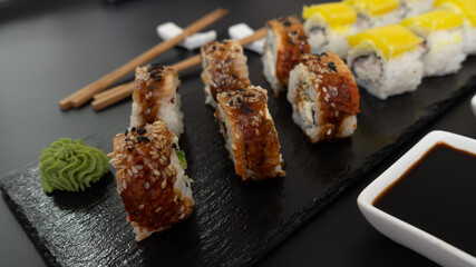 Sushi selection on black slate, food border background