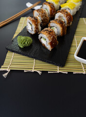 Sushi selection on black slate, food border background