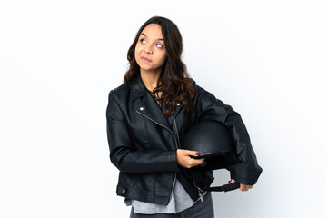Young woman holding a motorcycle helmet over isolated white background scheming something