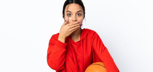 Young woman playing basketball over isolated white background covering mouth with hands