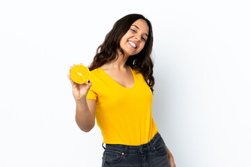 Young woman over isolated white background holding an orange