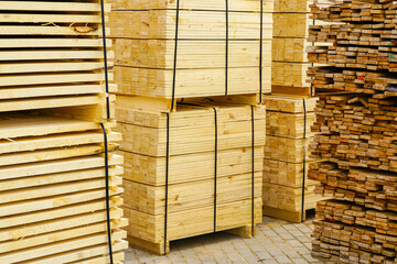 new packages of pine boards on pallets in the sawmill yard