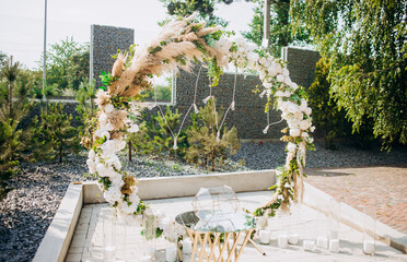 The round arch is decorated with flowers and dried flowers. Details of the wedding ceremony