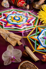 Ritual items for meditation and relaxation: Palo Santo smoking stick, mandalas, Tibetan singing bowl, figurines, incense, flowers and spices. Close-up, vertical format. Selective focus.