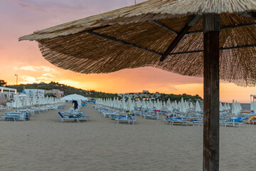 Umbrella in the foreground in a Vieste beach at sunset in summer.