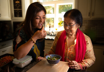 Daughter tasting food mother has made 