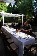 Woman arranging the outdoor dining table for a party 