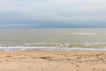 Close up view on calm sea water and sand. Summer vacation. Beach recreation. Ocean theme. Natural background.