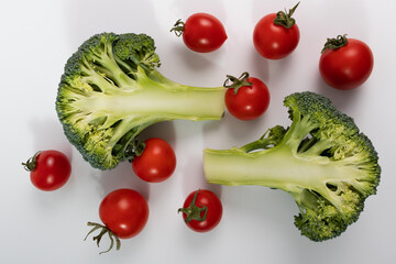 Broccoli with cherry tomatoes on a white, closeup. Healthy vegetables. Vitamins.
