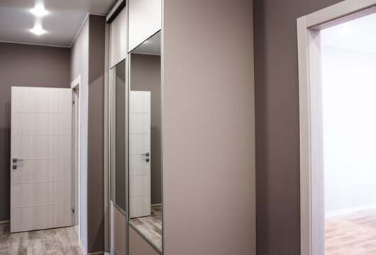 Spacious entrance hall in the apartment with built-in wardrobe and mirrors