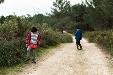 Obraz premium a Caucasian boy and girl play on a road in the bush.