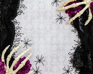 Skeleton hands on a black lacey background, damask and spiders
