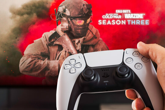 Male hand holding a Playstation 5 Dual Sense Controller with Call of Duty Season Three game blurred in the background. Rio de Janeiro, RJ, Brazil. October 2021.