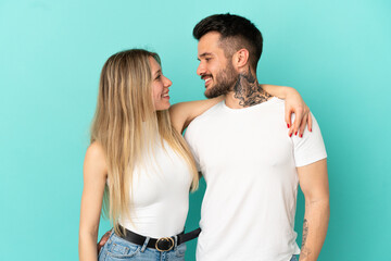 Young couple over isolated blue background happy and laughing