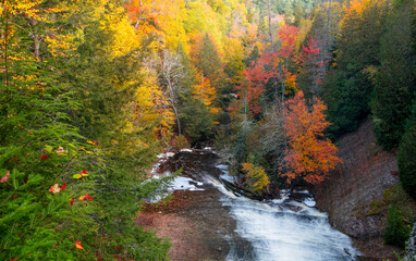 Bright fall foliage at Laughing whitefish water falls state park in Michigan upper peninsula