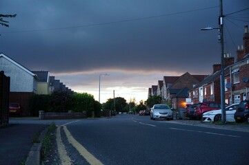 Suburban street with dark clouds in the sky