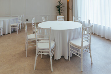 white round tables covered with a tablecloth to celebrate in the restaurant part of the decor and...