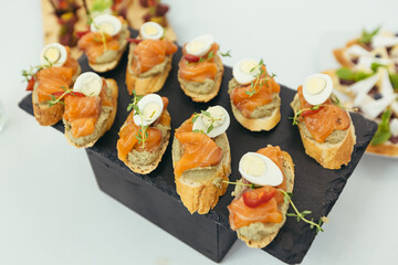 festive buffet table with various snacks of fish and meat