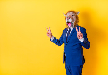 Businessman in lion mask making a victory gesture with both hands. Copy space with yellow...