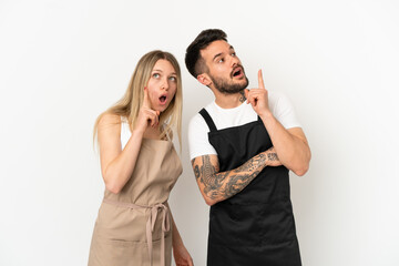 Restaurant waiter over isolated white background thinking an idea pointing the finger up