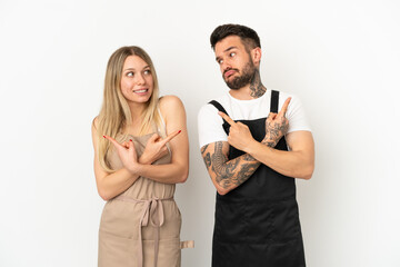 Restaurant waiter over isolated white background pointing to the laterals having doubts