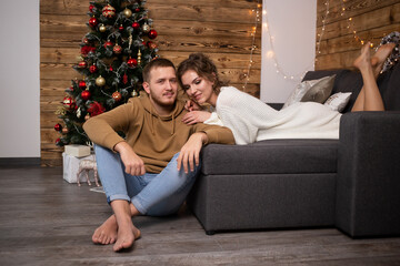 Couple enjoying their time together at home. Christmas tree on background.
