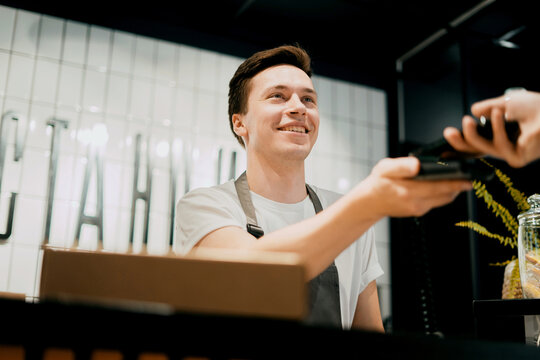 NFC Payment Phone. An Entrepreneur And His Restaurant Are A Small Business. A Man Works In A Cafe.