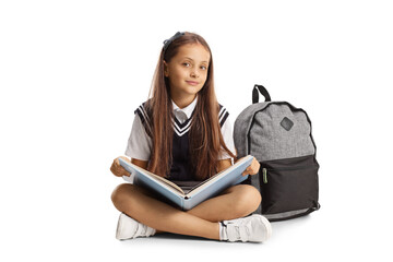 Schoolgirl sitting on the floor with a book on her lap