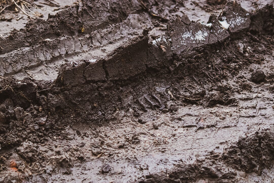 Dirty texture. Wet soggy earth after rain. Mud surface in autumn. Tire marks in dirt. Track for racing
