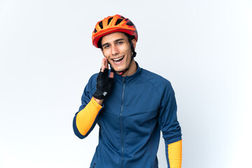 Young cyclist man isolated on background shouting with mouth wide open