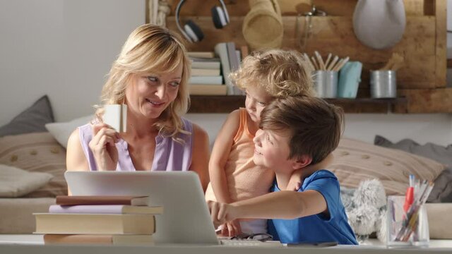 family online shopping by credit card, mother with daughter and son use the computer at home, surf the internet looking for a purchase or gift, boy is disappointed because he disagrees with his mom