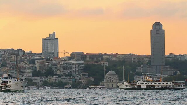Bezmialem Valide Sultan Mosque and high hotel buildings in the distance. Besiktas District at sunset in Istanbul, Turkey. 
