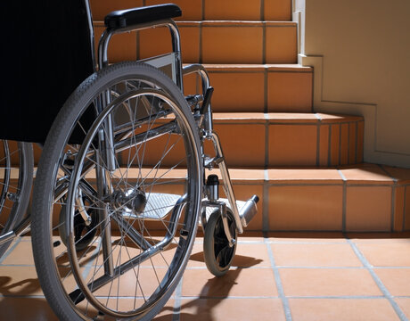 Empty wheelchair at the base of terracotta stairs