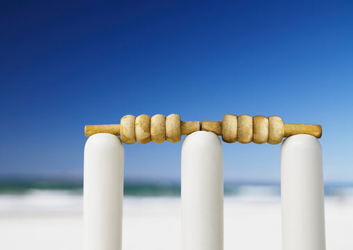 Bails on top of stumps to create a wicket ready to play cricket at the beach